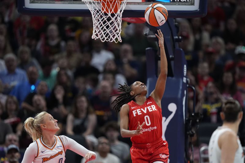 Indiana Fever guard Kelsey Mitchell (0) shoots against Phoenix Mercury's Sophie Cunningham during the first half of a WNBA basketball game, Friday, Aug. 16, 2024, in Indianapolis. (AP Photo/Darron Cummings)