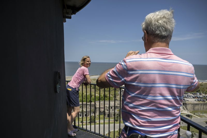 A couple visiting from Germany stops to take photos from the top of the Tybee Island lighthouse on May 23, 2024 while the Tybee Island Historical Society makes repairs to the 18th century lighthouse on Georgia's coast. (AJC Photo/Stephen B. Morton)