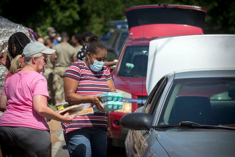 SUMMERTOWN, GA - JULY 14, 2020: Volunteers with the Summertown Food Pantry places food into the back seat of a car. Most members of the food drive practice social distancing by placing boxes in the trunk or back seat. (AJC Photo/Stephen B. Morton)