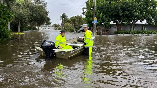 This photo provided by Venice Police Department rescue crews assist residents after conducting door-to-door wellness checks, in coastal areas that were flooded by Hurricane Helene on Friday, Sept. 27, 2024 in Venice, Fla . (Venice Police Department via AP)