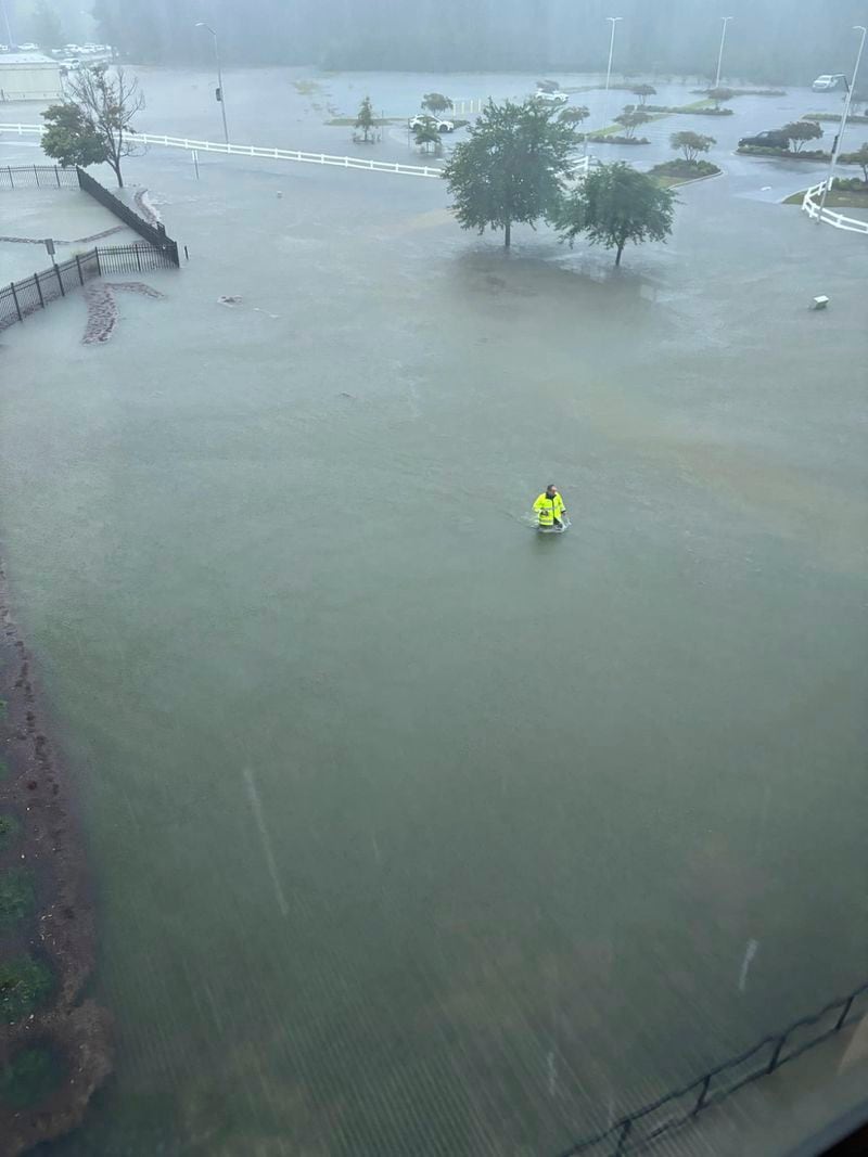 This photo provided by Brunswick County Sheriff's Office shows a person walking through flooded water in Brunswick County, N.C., after a storm dropped historic amounts of rain, Monday, Sept. 16, 2024. (Brunswick County Sheriff's Office via AP)