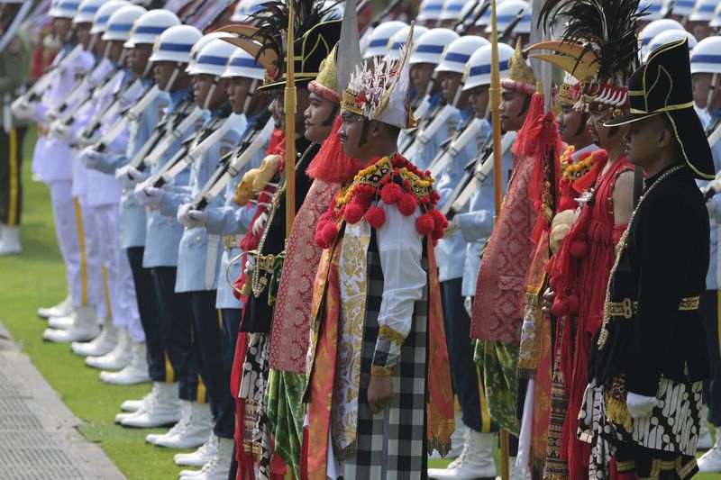 Participants in traditional attire and uniformed personnel stand in formation ahead of the ceremonial welcome for Pope Francis at the Presidential Palace in Jakarta Wednesday, Sept. 4, 2024. (Bay Ismoyo/Pool Photo via AP)