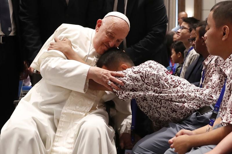 Pope Francis, left, blesses a beneficiary from charitable organizations at the Indonesian Bishops' Conference Headquarters in Jakarta Thursday, Sept. 5, 2024. (Adi Weda/Pool Photo via AP)