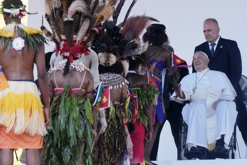 Pope Francis meets with people in traditional dress after giving an address during meeting with young people in the Sir John Guise Stadium in Port Moresby, Papua New Guinea, Monday, Sept. 9, 2024. (AP Photo/Mark Baker)