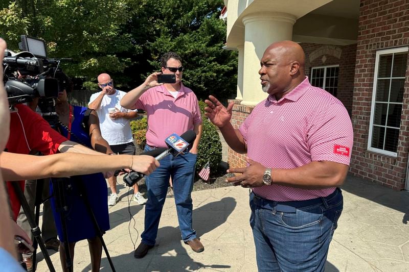 North Carolina Republican gubernatorial candidate Mark Robinson, right, speaks with reporters outside the Olympic Family Restaurant in Colfax, N.C., where Robinson held a campaign event on Monday, Aug. 26, 2024. (AP Photo/Gary D. Robertson)