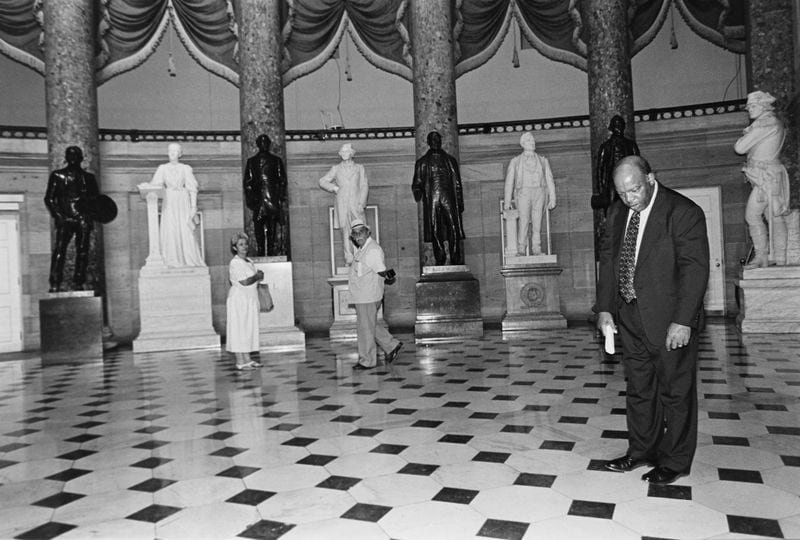 Representative John Lewis, D-Ga., giving a Capitol tour to a constituent demonstrates how the "sound system" works. Between 2 spots about 20 feet apart in Statuary Hall you can whisper in one and be distinctly heard in the other. July 22, 1993 (Photo by Maureen Keating/CQ Roll Call via AP Images)