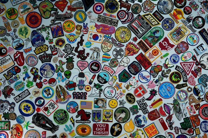 A wall displays some of the thousands of patches sent to Oliver Burkhardt when he was undergoing cancer treatment at age 9, inside the offices of the Oliver Patch Project, Wednesday, Sept. 4, 2024, in Miami. (AP Photo/Rebecca Blackwell)