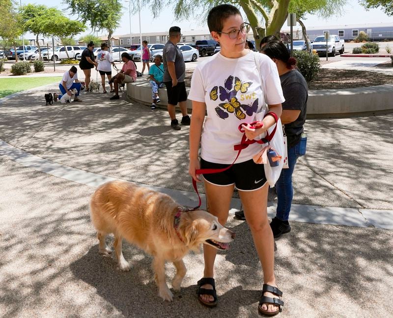 FILE - Rori Chang, of Glendale, Ariz., waits in line with her dog Ava to get microchipped at the Maricopa Country Animal Care & Control facility Friday, June 30, 2023, in Phoenix. As most people look forward to July Fourth celebrations, those with pets are searching for solutions to the anxiety that fireworks bring. (AP Photo/Ross D. Franklin, File)