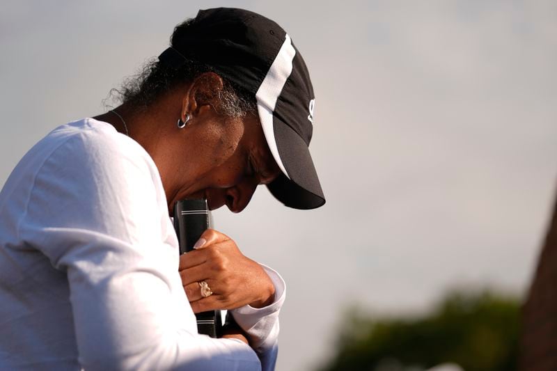 Chimain Douglas, of Grayson, Ga., holds a Bible as she cries near Apalachee High School as she mourners for the slain students and teachers on Thursday, Sept. 5, 2024, in Winder, Ga. (AP Photo/Brynn Anderson)