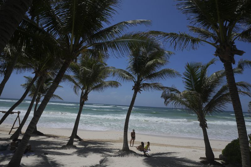 Tourists lounge on a beach ahead of Hurricane Beryl's expected arrival, in Tulum, Mexico, Thursday, July 4, 2024. (AP Photo/Fernando Llano)