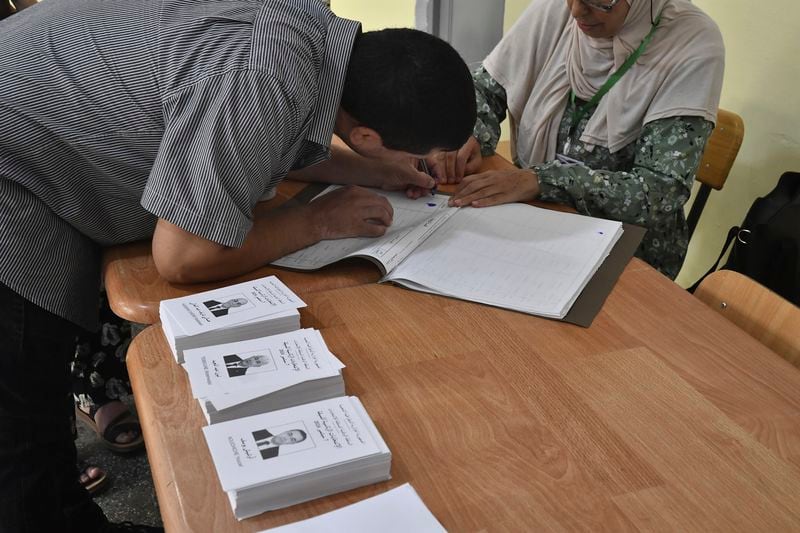 A voter prepares to cast his ballot inside a polling station during the presidential election, Saturday, Sept. 7, 2024, in Algiers, Algeria. (AP Photo/Fateh Guidoum)