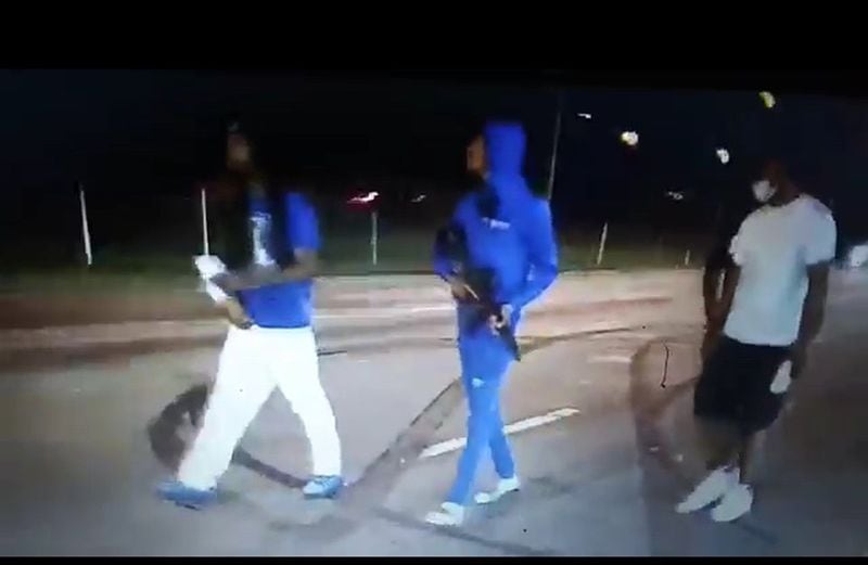 A few armed guys are seen in this screenshot of a video widely viewed online, marching down the street by the Wendy’s on University Avenue in southwest Atlanta, seconds before bullets started flying the night of June 19, 2020. Someone else, not them, started the gunfight. (caption info: Bill Torpy)