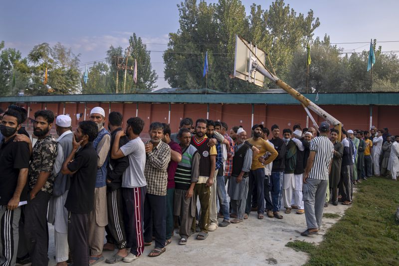 Kashmiri people queue up at a polling booth to cast their vote during the second phase of the assembly election in the outskirts of Srinagar, Indian controlled Kashmir, Wednesday, Sept. 25, 2024. (AP Photo/Dar Yasin)