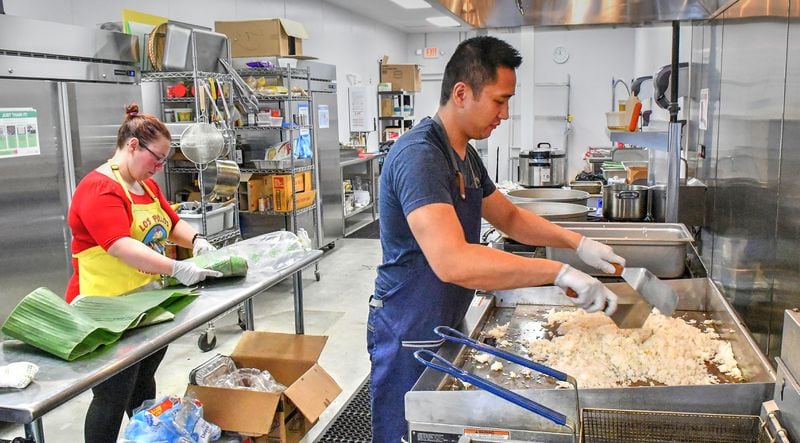 Grace Wynn cuts banana leaves for plating dishes while Mike Pimentel prepares sinangag (garlic fried rice) at his commissary on Covington Highway. (CHRIS HUNT FOR THE ATLANTA JOURNAL-CONSTITUTION)