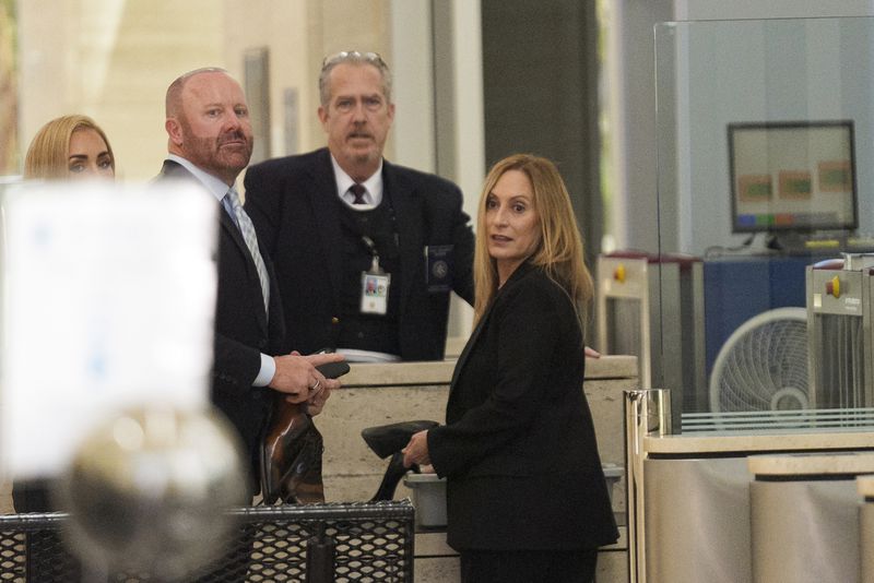 Mathew Bowyer, second from left, a Southern California bookbinder, and his attorney Diane Bass, right, enter federal court in Santa Ana, Calif., Friday, Aug. 9, 2024. (AP Photo/Damian Dovarganes)