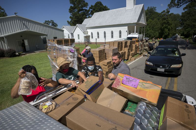 Volunteers load the bed of a pickup truck with food. (AJC Photo/Stephen B. Morton)