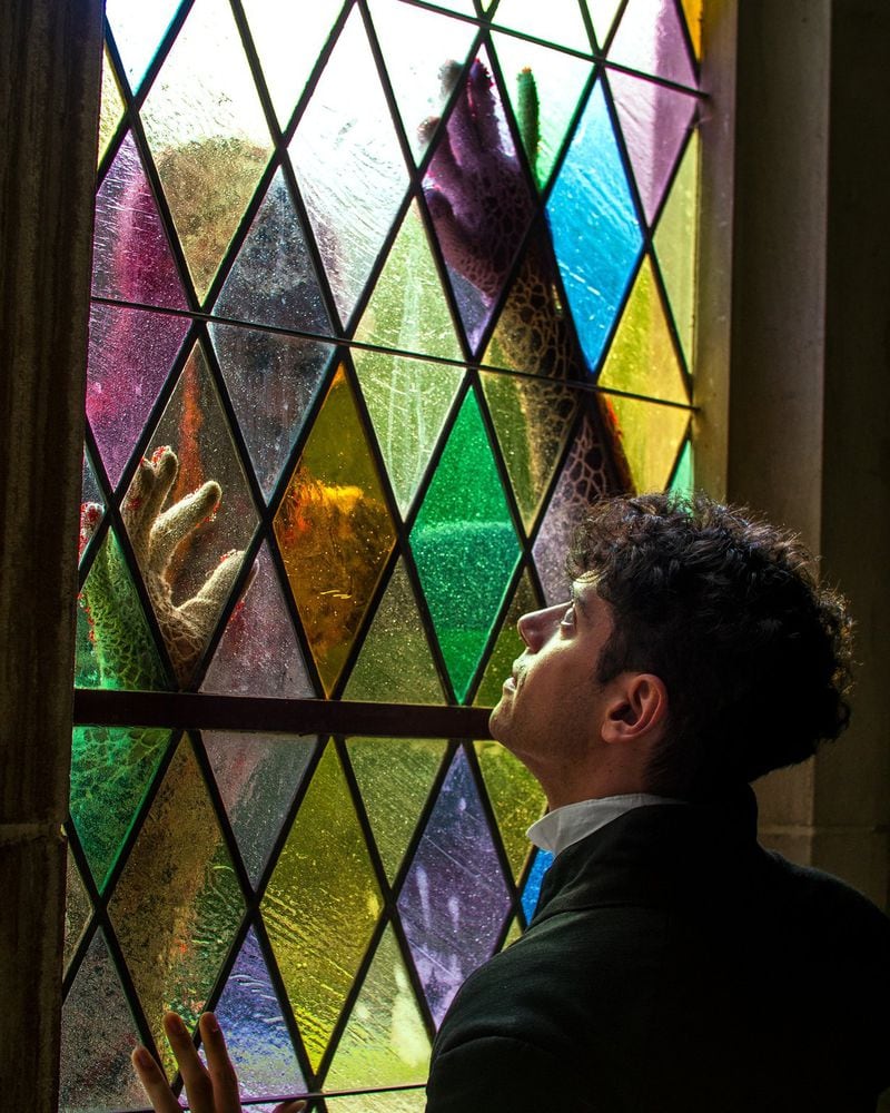 Victor Frankenstein (played by Jake Krakovsky) looks in horror at his monstrous creation through the stained-glass window of the St. John’s Lutheran Church. This month Found Stages is presenting an immersive version of the Frankenstein story called “Frankenstein’s Funeral” at this gothic Midtown church. CONTRIBUTED: FOUND STAGES/JOSH MARSH