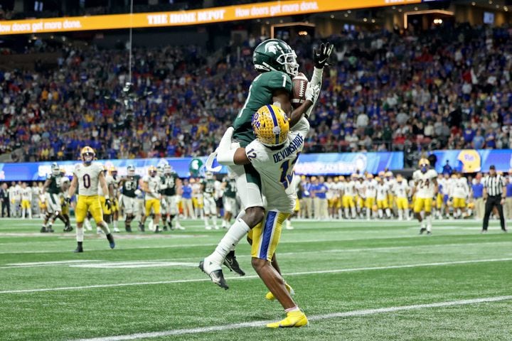 Michigan State Spartans wide receiver Jayden Reed (1) catches the go-ahead touchdown against Pittsburgh Panthers defensive back M.J. Devonshire (12) in the fourth quarter of the Chick-fil-A Peach Bowl at Mercedes-Benz Stadium in Atlanta, Thursday, December 30, 2021. JASON GETZ FOR THE ATLANTA JOURNAL-CONSTITUTION