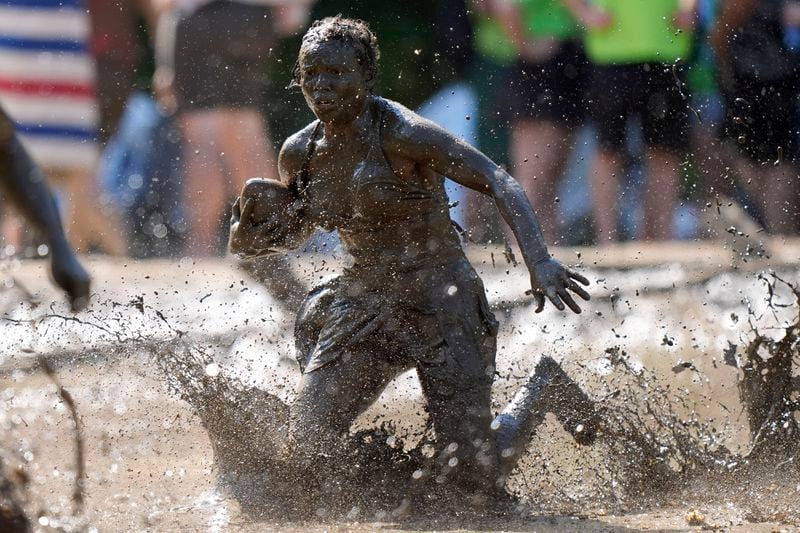 Mahala Smith, of Sabattus, Maine, scrambles for yardage during a women's football game at the Mud Bowl in North Conway, N.H., Saturday, Sept. 7, 3024. (AP Photo/Robert F. Bukaty)