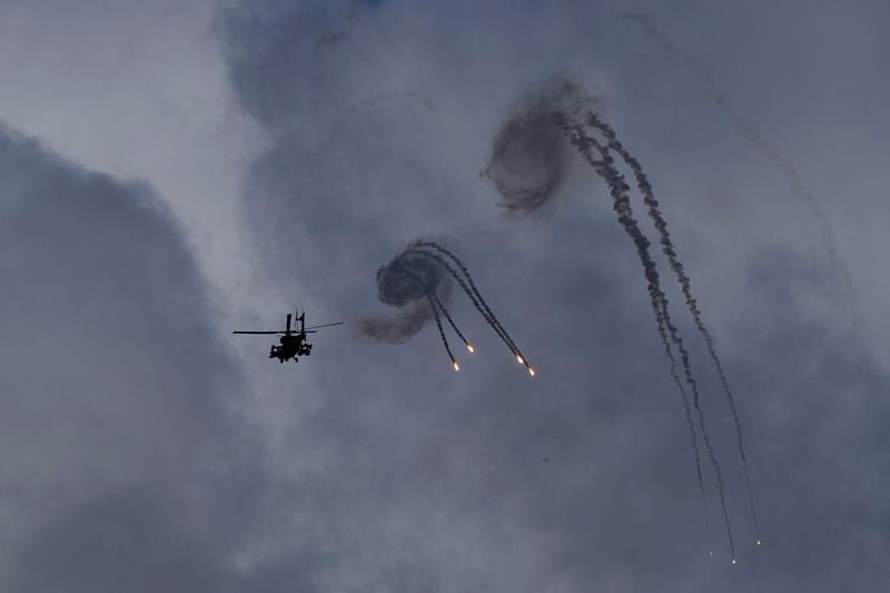 An Israeli Apache helicopter releases flares near the Israeli-Lebanon border, as seen from northern Israel, Wednesday, Oct. 2, 2024. (AP Photo/Baz Ratner)