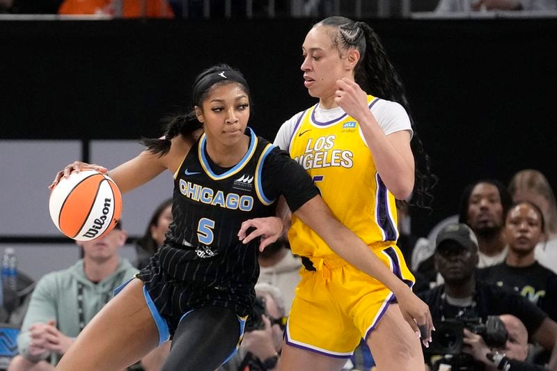 FILE - Chicago Sky's Angel Reese (5) drives to the basket as Los Angeles Sparks' Dearica Hamby defends during the first half of a WNBA basketball game, May 30, 2024, in Chicago. Not even a WNBA basketball game is an escape from the arguments and polarization that are so common in American life these days. (AP Photo/Charles Rex Arbogast, File)