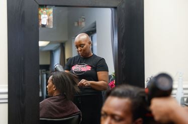 Felicia Flores, founder of Baldie Con dries her client Erica Bledsoe’s hair at her salon in Buckhead on Wednesday, Sept. 25, 2024. Flores launched Baldie Con a few years ago for women, children and men with hair loss issues. (Natrice Miller/ AJC)