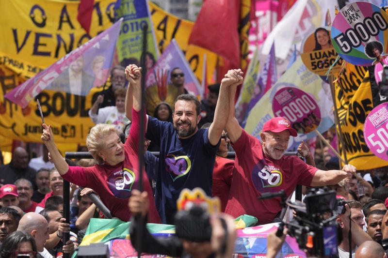 Mayoral candidate Guilherme Boulos of the Socialism and Liberty Party, center, campaigns with Brazilian President Luiz Inacio Lula da Silva, right, and his running mate Marta Suplicy, left, the day before elections in Sao Paulo, Saturday, Oct. 5, 2024. (AP Photo/Andre Penner)