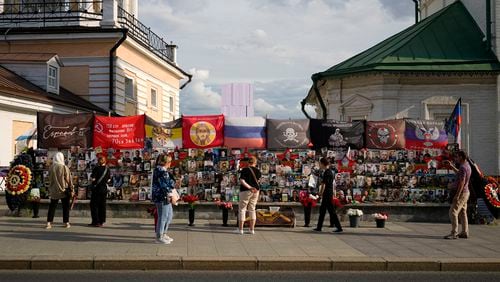 People stand near an improvised memorial to Russian mercenary chief Yevgeny Prigozhin and others who died in a plane crash with him last year, near the Kremlin, in Moscow, Russia, on Monday, July 29, 2024. The Russian mercenary group Wagner suffered its heaviest loss in Africa's Sahel region late last week following an attack that was launched separately by both local and al-Qaida-linked rebels. At least 50 Wagner fighters were reported killed in the attack which raised questions about the group's capacity and whether such an attack could pose any setback to its activities. (AP Photo/Pavel Bednyakov)