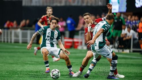 Santos Laguna forward Javier Correa (center) fights for the ball against Atlanta United midfielder Bartosz Slisz during the first half of a Leagues Cup match at Mercedes-Benz Stadium on Sunday, Aug. 4, 2024, in Atlanta.

(Miguel Martinez/ AJC)