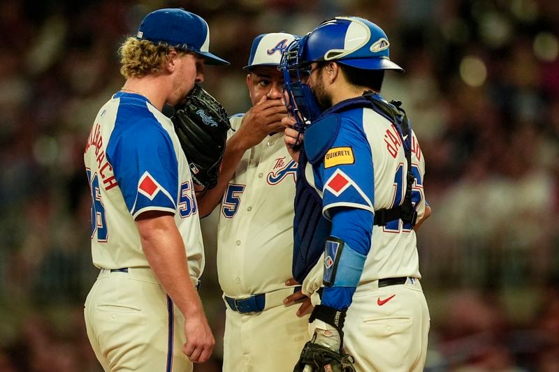 Atlanta Braves pitcher Spencer Schwellenbach (56) speaks with bullpen coach Erick Abreu (85) and catcher Travis d'Arnaud (16) on the mound in the fourth inning of a baseball game against the Toronto Blue Jays, Saturday, Sept. 7, 2024, in Atlanta.(AP Photo/Mike Stewart)