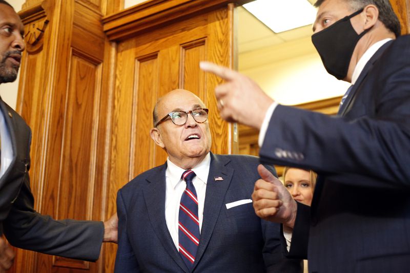 Rudy Giuliani, an attorney for then-President Donald Trump, walks into a state Senate hearing at the Georgia Capitol in Atlanta on Dec. 3, 2020. During that hearing, Giuliani misrepresented edited footage of vote-counting at State Farm Arena, pointing to bins that he said were “suitcases” of ballots being smuggled in. He called the footage "a smoking gun." Trump, who repeatedly referred to the footage as evidence of corruption that had cost him the election, was notified at least four different times that the allegations were false, according to the final report of the U.S. House committee investigating the Jan. 6, 2021, attack on the U.S. Capitol. Then-Deputy Attorney General Jeffrey Rosen told Trump on Dec. 15: “It wasn’t a suitcase. It was a bin. That’s what they use when they’re counting ballots. It’s benign.” (Rebecca Wright for the Atlanta Journal-Constitution)