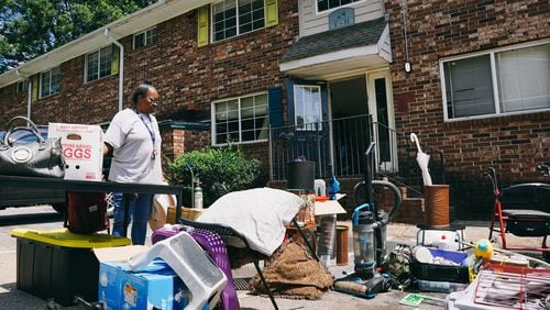 Constance Alford looks over her belongings strewn in the parking lot of her apartment building after her eviction due to alleged unpaid rent in southwest Atlanta, Georgia on Monday, July 24, 2023. (Olivia Bowdoin for the Atlanta Journal-Constitution) 