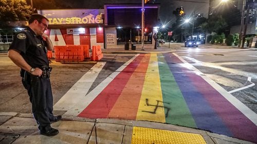 Atlanta police Lt. Z. Kramer looks over the latest defacing of the rainbow crossing at 10th Street and Piedmont Avenue early Friday morning.