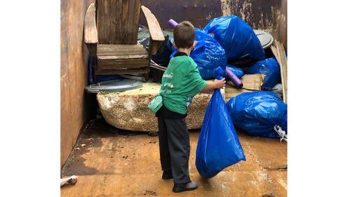 A young volunteer helps collect trash during the 32nd annual Shore Sweep of the Lake Lanier Association.