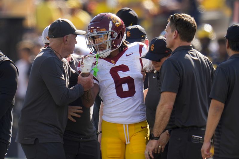 Southern California wide receiver Makai Lemon (6) is helped off the field in the first half of an NCAA college football game against Michigan in Ann Arbor, Mich., Saturday, Sept. 21, 2024. (AP Photo/Paul Sancya)