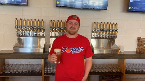 Pontoon Brewing co-owner Sean O’Keefe is shown behind the bar at the new taproom in Tucker known as “The Lodge.” (Bob Townsend for The Atlanta Journal-Constitution)