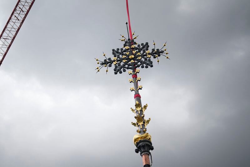 Notre Dame de Paris cathedral's Croix du Chevet is lifted to be reinstalled, Friday, May 24, 2024, in Paris. The Croix du Chevet is the only piece of the cathedral roof that did not burn in the devastating April 2019 fire. (AP Photo/Thibault Camus)