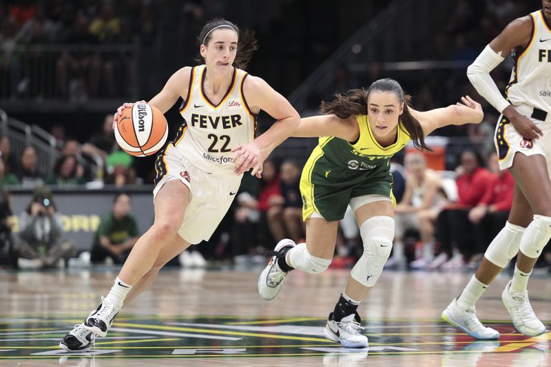 Indiana Fever guard Caitlin Clark (22) drives as Seattle Storm guard Nika Muhl defends during the second half of a WNBA basketball game, Wednesday, May 22, 2024, in Seattle. The Storm won 85-83. (AP Photo/Jason Redmond)