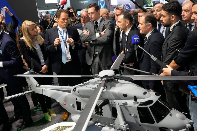 Jordan Bardella, center, president of the far-right National Front party, looks ata replica of an Airbus NH90 NFH rescue helicopter at the Eurosatory Defense and Security exhibition, Wednesday, June 19, 2024 in Villepinte, north of Paris. Jordan Bardella, hoping to become France's prime minister, appealed Tuesday to voters to hand his party a clear majority after French President Emmanuel Macron's announcement on June 9 that he was dissolving France's National Assembly, parliament's lower house.( AP Photo/Michel Euler)