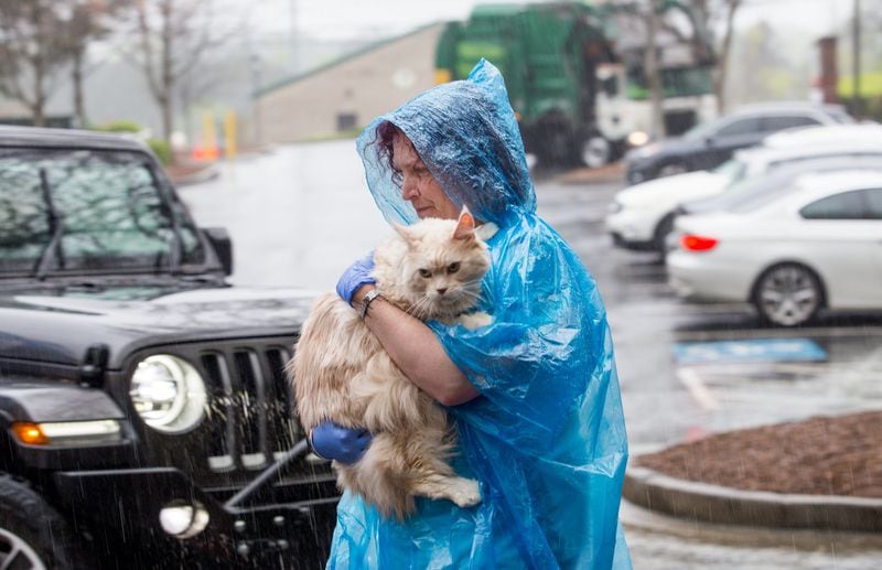 Laura Abbott, a radiation oncology technician at BluePearl Specialty and Emergency Hospital, carried in her patient Falcon, a Maine Coon, for treatment. The emergency animal hospital in Sandy Springs is continuing to operate during the coronavirus pandemic with curb-side, drive-up service for checking in pets. (Jenni Girtman for The Atlanta Journal-Constitution)