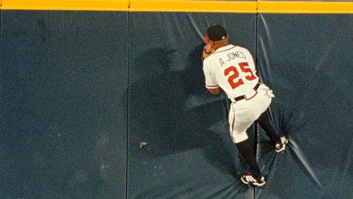 Andruw Jones climbs the wall at Turner Field to make a catch against the Houston Astros on Aug. 9, 1999, in Atlanta.