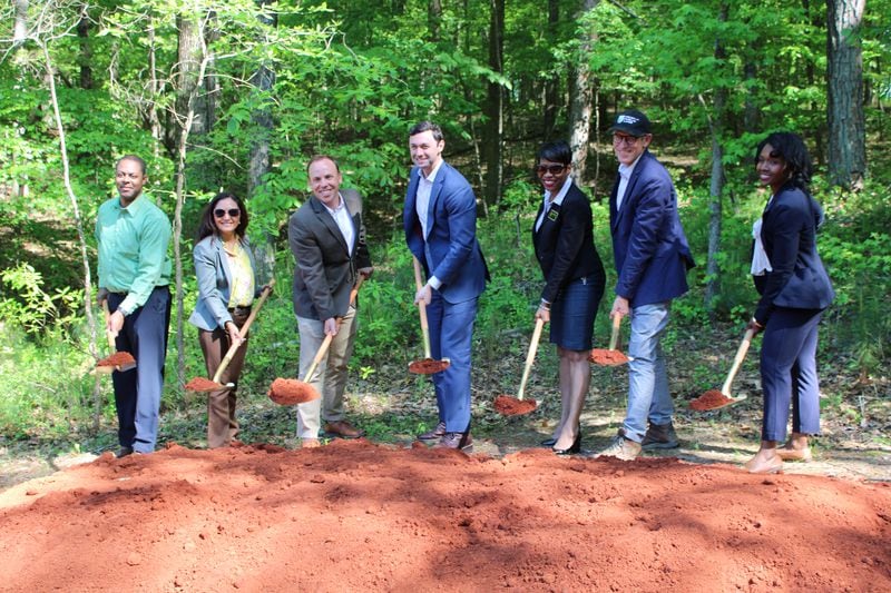 (Left to right) Cobb County Department of Transportation engineers Russ Ford and Ligia Florim, Cobb DOT Director Drew Raessler, U.S. Sen. Jon Ossoff, Commissioner Monique Sheffield, Trust for Public Land's Georgia director George Dusenbury and Chairwoman Lisa Cupid break ground on the Chattahoochee RIverLands project in Mableton on Monday, April 24, 2023. (Taylor Croft/taylor.croft@ajc.com)