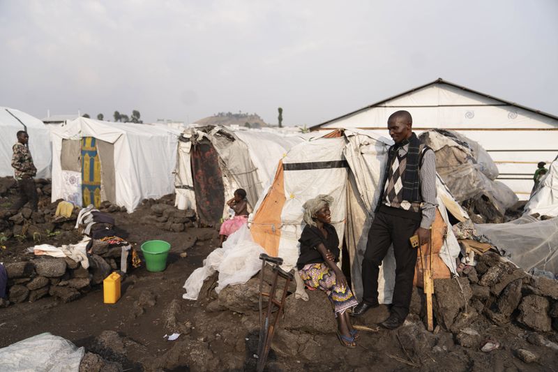 Faustin Mahoro, head of the Bulengo refugee camp in Goma, Congo, speaks with Sarah Bagheni after the World Health Organization had declared Thursday, Aug, 15, 2024, the increasing spread of mpox in Africa a global health emergency, warning the virus might ultimately spill across international border. (AP Photo/Moses Sawasawa)