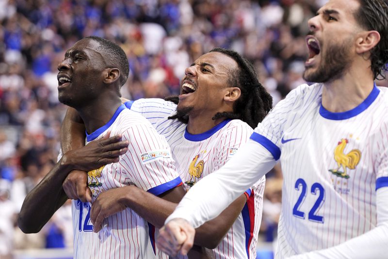 Randal Kolo Muani of France, left, and his teammates celebrate their side's first goal during a round of sixteen match between France and Belgium at the Euro 2024 soccer tournament in Duesseldorf, Germany, Monday, July 1, 2024. (Fabio Ferrari/LaPresse via AP)