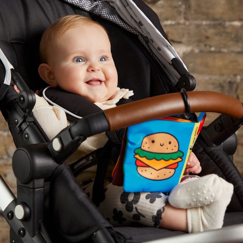 A colorful crinkle fabric book featuring emoji-like food entertains babies.
(Courtesy of Mudpuppy)