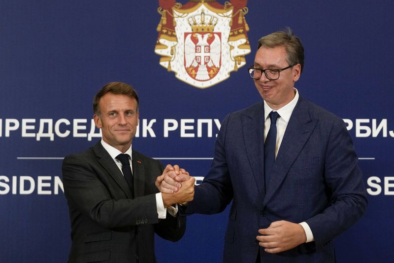 French President Emmanuel Macron clasps hands with Serbian President Aleksandar Vucic after a joint press conference in Belgrade, Serbia, Thursday, Aug. 29, 2024. French President Emmanuel Macron started a two-day state visit to Serbia with the focus on the sale of 12 Rafale multi-purpose fighter jets to a country that has maintained close ties to Russia despite its aggression on Ukraine. (AP Photo/Darko Vojinovic)