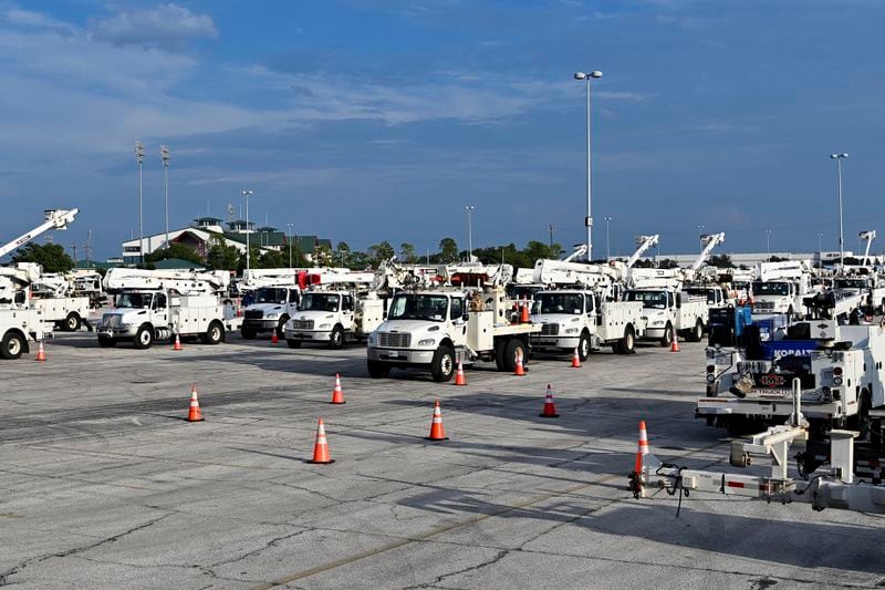 Utility trucks sit parked at a CenterPoint Energy staging center at the Houston Race Track in Houston, Wednesday, July 10, 2024. Millions of residents lost power after Hurricane Beryl made landfall. (AP Photo/Maria Lysaker)