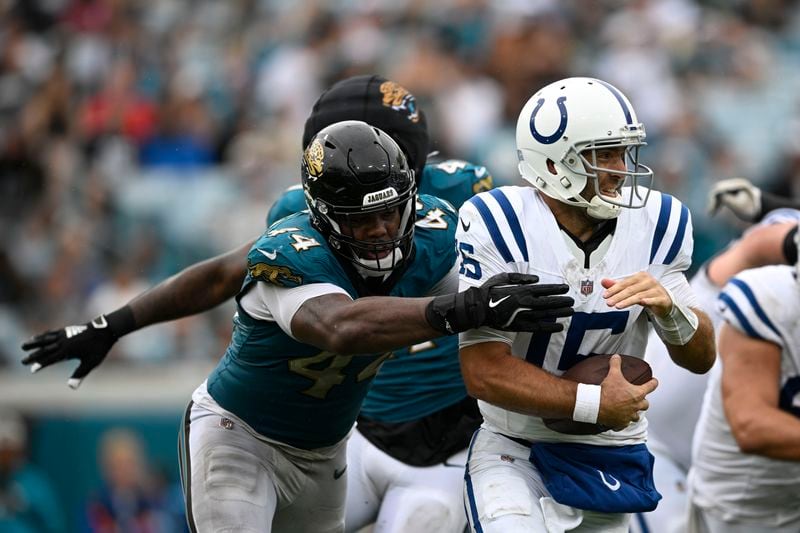 Indianapolis Colts quarterback Joe Flacco (15) is pressured by Jacksonville Jaguars' Travon Walker (44) during the second half of an NFL football game, Sunday, Oct. 6, 2024, in Jacksonville, Fla. (AP Photo/Phelan M. Ebenhack)