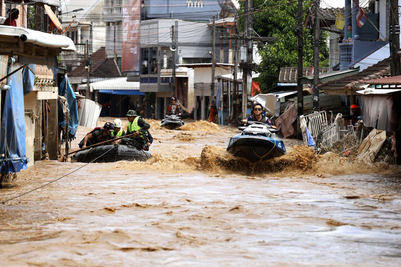 A rescue worker uses jet skis to search for victims in flooded areas in Chiang Rai Province, Thailand, Friday, Sept. 13, 2024. (AP Photo/Sarot Meksophawannakul)