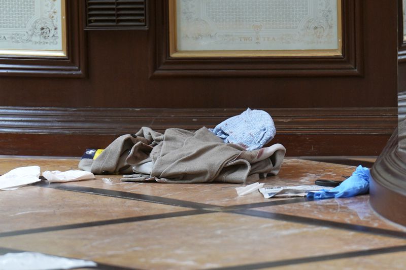 Discarded clothing and emergency medical equipment is seen inside the TWG Tea shop in Leicester Square, London, as a man has been arrested after an 11-year-old girl and 34-year-old woman were stabbed, in London, Monday, Aug. 12, 2024. (James Manning/PA via AP)